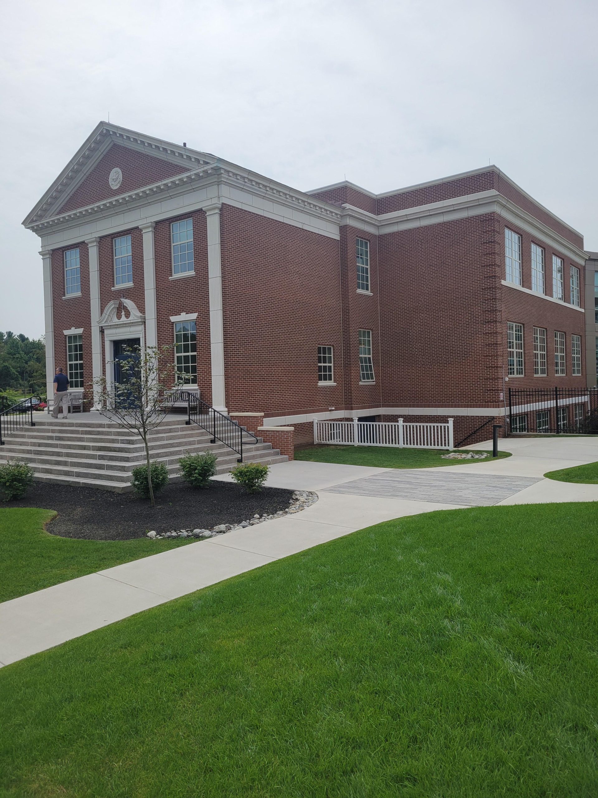 Applying caulk to cracked brick joints on a house foundation